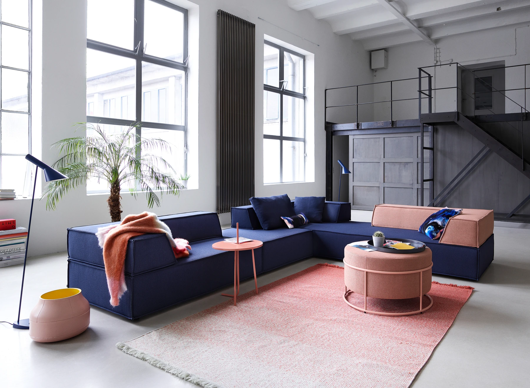 COR Trio als blaue Sitzlandschaft mit roséfarbenen Akzenten in einem hellen Loft